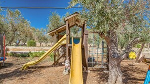 Ein Spielplatz mit einer gelben Rutsche und einer hölzernen Kletterkonstruktion.