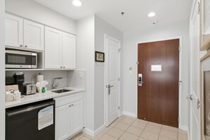A kitchen with white cabinets, a microwave, a coffee maker, and a dishwasher. - Studio condo at Luau in Sandestin Golf & Beach Resort (Miramar Beach)