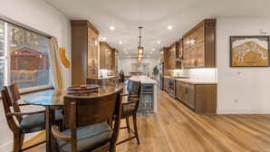 Une cuisine moderne avec des meubles en bois, un îlot central et un coin repas avec des chaises.