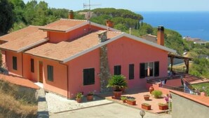 A two-story house with a red-tiled roof, a balcony, and a view of the sea. - Villa Calamita apartment 1 (Capoliveri isola d'Elba)