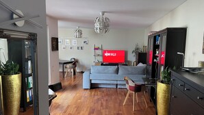 A living room with a sofa, a TV, a dining table, chairs, and decorative plants. - 5+ persons (wheelchair accessible), 2nd floor, Neckargemünd (old town), near Heidelberg (Neckargemünd)