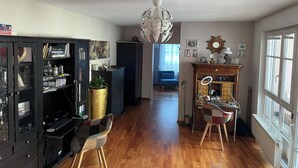 A spacious living area with a wooden floor, a black entertainment unit, a blue sofa, and a large chandelier. - 5+ persons (wheelchair accessible), 2nd floor, Neckargemünd (old town), near Heidelberg (Neckargemünd)