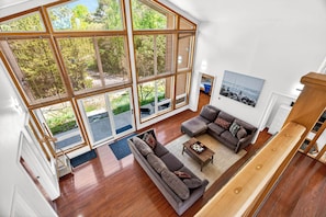 A spacious living room with a large sliding glass door leading to an outdoor area, a sectional sofa, and a coffee table.