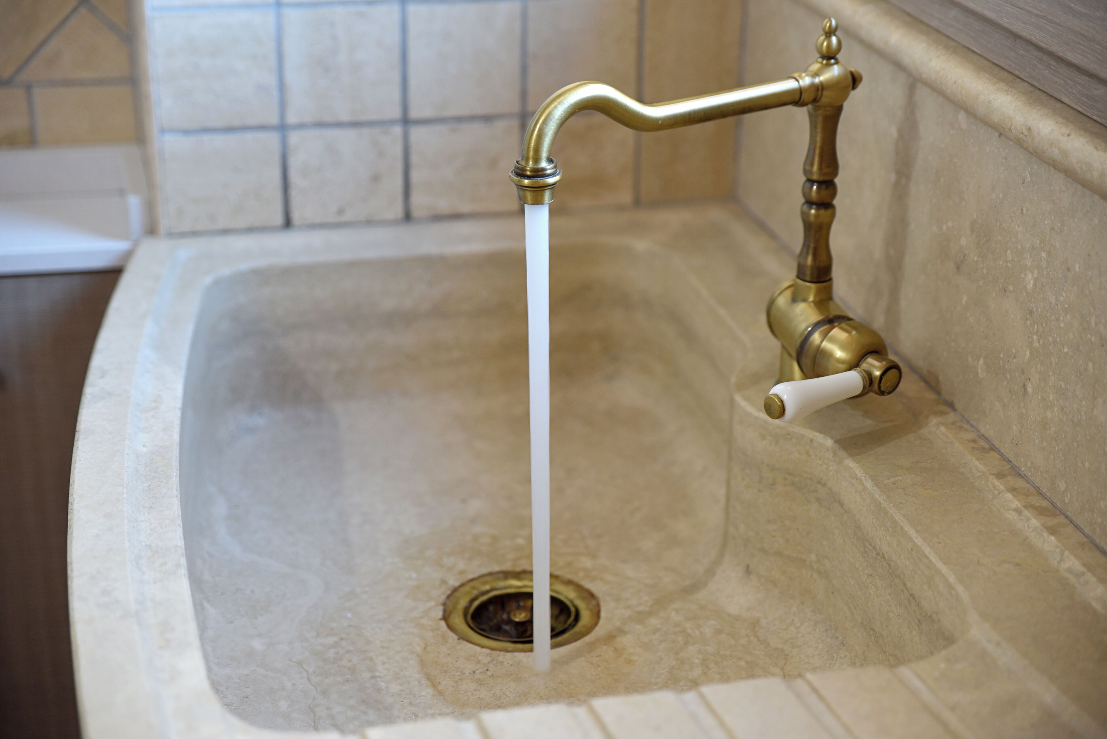Ein Waschbecken mit einem laufenden Wasserhahn und Ablauf.