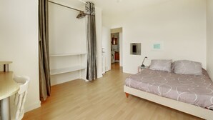 A bedroom with a bed, a chair, a table, and a wardrobe. - Pleasant, bright T3 on top floor (8), not overlooked, close to parks/services (Rennes)