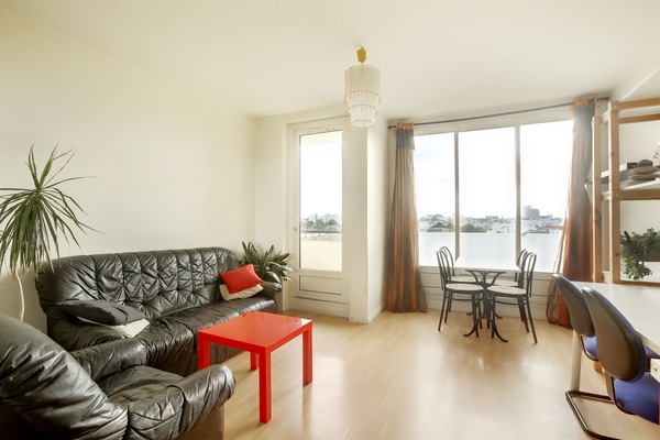 Séjour/salon/salle à manger accès au balcon, espace bureau, étagères, vue Ouest