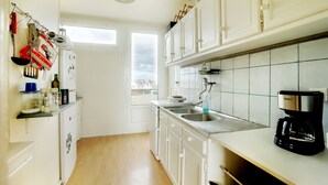 A kitchen with white cabinets, a stainless steel sink, and a coffee maker. - Pleasant, bright T3 on top floor (8), not overlooked, close to parks/services (Rennes)