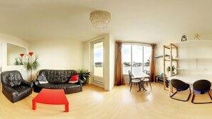 A living room with a black leather sofa, a red coffee table, and a dining area with a white table and chairs. - Pleasant, bright T3 on top floor (8), not overlooked, close to parks/services (Rennes)