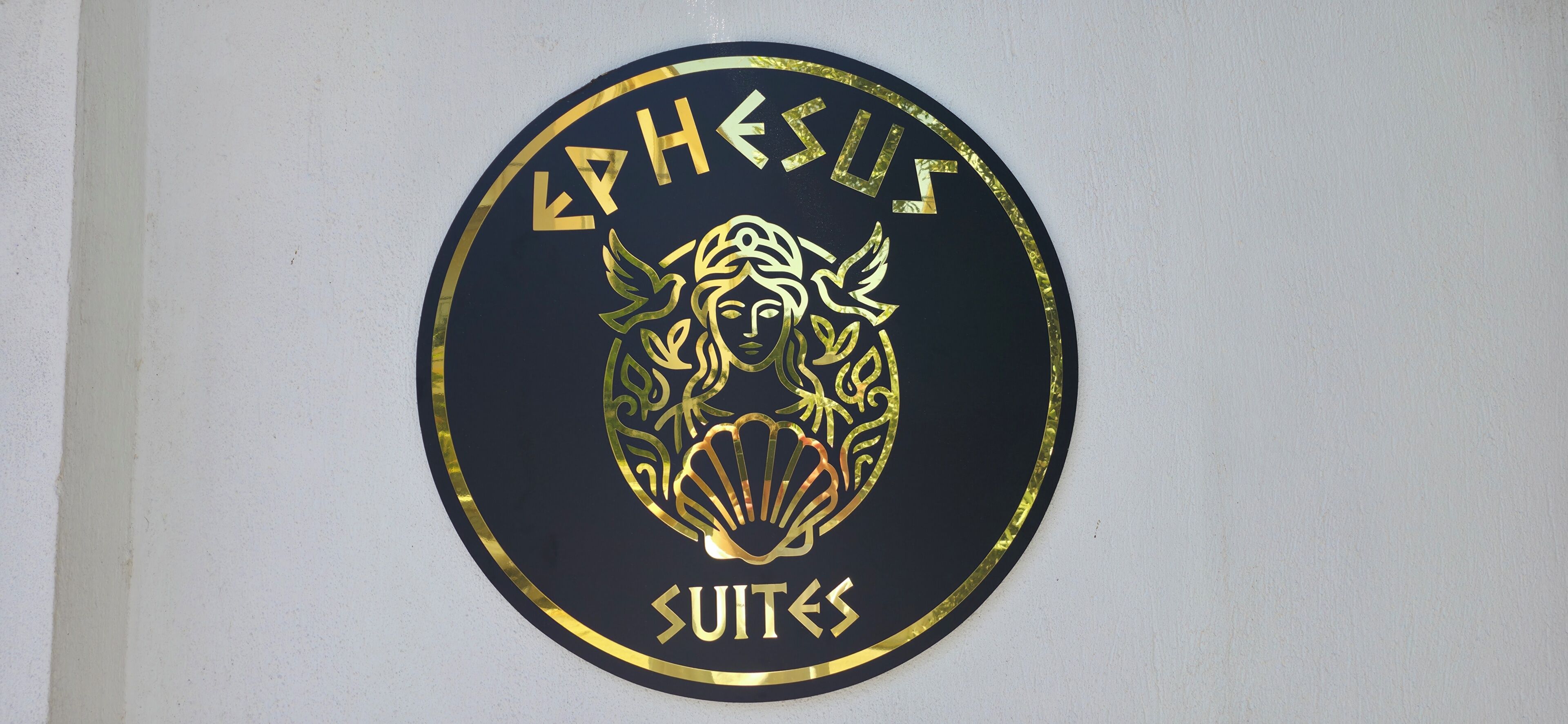 Ein kreisiges Logo mit dem Text 'EPHEUS SUITES' und einem stilisierten Design.