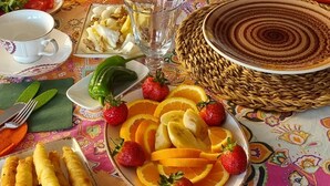 A breakfast table with various dishes, a coffee maker, and kitchen appliances.