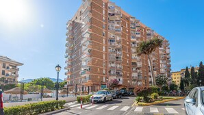 A multi-story residential building with balconies, a parking area, and a street lamp. - Spain Breaks - 2 bed apt With 2 Pools, Airco, Wifi (Benalmádena)