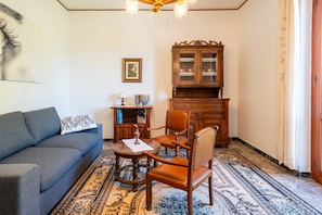 A living room with a sofa, chairs, a table, a cabinet, and a patterned rug. - Holiday Home 'Casa Corniolo' with Mountain View, Private Terrace and Balcony (Monte San Savino)