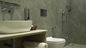 Ein modernes Badezimmer mit einem großen Waschbecken, Toilette und Duschbereich.