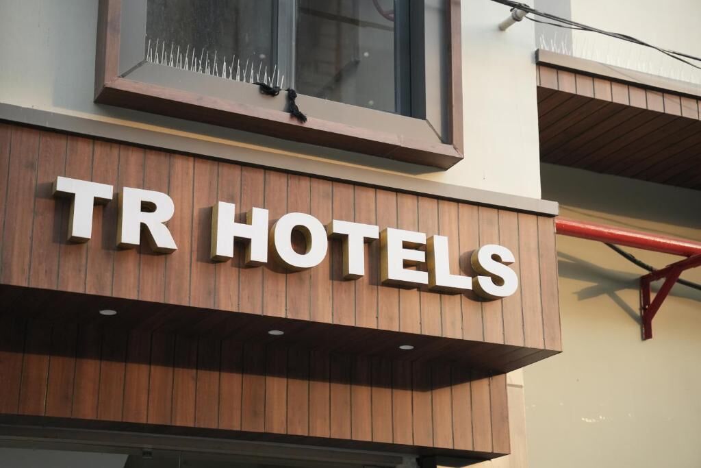 Une enseigne TR HOTELS avec une façade en bois et une fenêtre au-dessus.