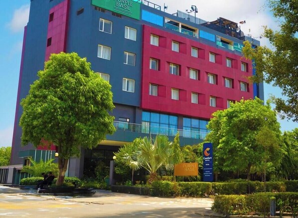 A multi-story hotel with a modern design, featuring a prominent sign for 'Purple Basil' and a logo for 'Comfort Hotel.' - Comfort Hotel Vista (Lucknow)