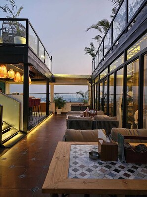 A modern rooftop bar with a view of the city skyline, outdoor seating, and potted plants. - Comfort Hotel Vista (Lucknow)