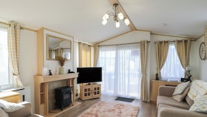 Ein gemütliches Wohnzimmer mit Kamin, Flachbildfernseher und einer Couch.