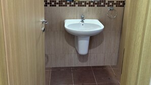 Un bagno con lavandino, specchio e pareti piastrellate.