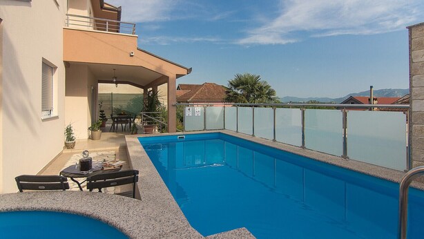 A swimming pool with a covered patio area, a table, and chairs. - Holiday Home Vele with pool (Vrgorac)