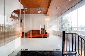 Ein modernes Interieur mit Glaswand, Holzboden und schwarzer Geländer.