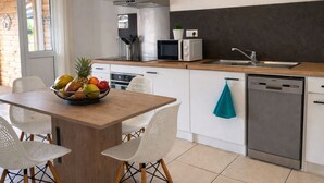 A modern kitchen with white cabinets, a wooden countertop, a sink, a microwave, and a dishwasher. - Lodge with shared pool - 4 guests (Le Tampon)