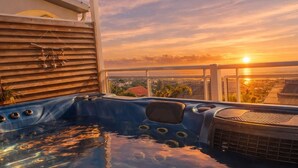 A hot tub with a view of the sunset and a cityscape. - Lodge with shared pool - 4 guests (Le Tampon)