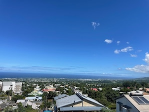 Ein Wohngebiet mit Häusern, einige davon mit Solaranlagen, und einem strahlend blauen Himmel.