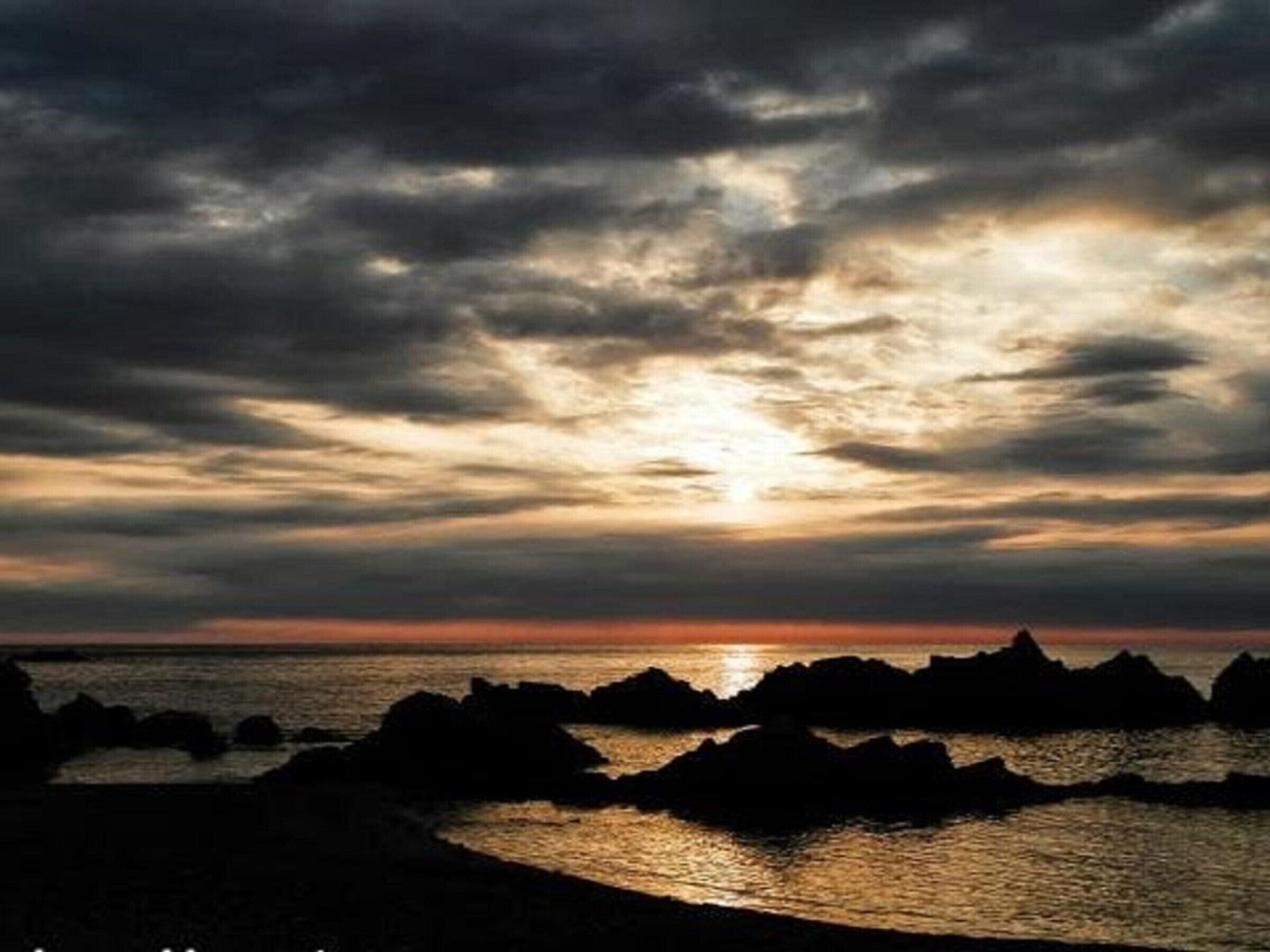 A coastal sunset with rocky outcrops.