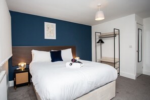 A bedroom with a bed, bedside tables, a hanging light fixture, a map on the wall, and a bunk bed structure. - Vacant Nests | The Freda | Modern 3BR Home | (Sunderland)