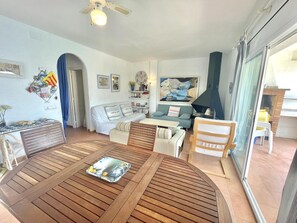 Ein Wohnzimmer mit Holztisch, Sofa, Sessel und Kamin.