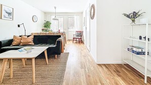 Una sala de estar moderna con un sofá, una mesa de centro y un comedor con sillas y una mesa.