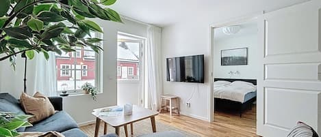 A modern living room with a sofa, coffee table, and a TV mounted on the wall.
