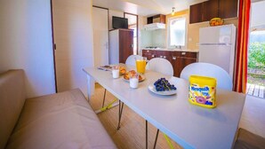 A compact kitchenette with a dining area, a refrigerator, a microwave, and a sink. - Mobile home, pets allowed, AC - 6 guests (Frontignan)