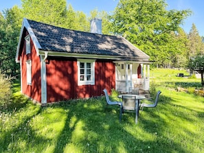 A red wooden house with a porch and a table with chairs. - Kråktorpet by Interhome (Mariannelund)
