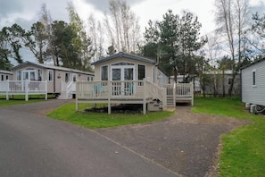 A row of mobile homes with a central building featuring a porch and a staircase.