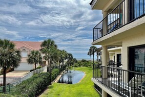 A residential building with a swimming pool, palm trees, and a view of the ocean. - PAC 201...Great Ocean View, 2nd floor 2BR/2BA condo overlooks lagoon (Saint Augustine)