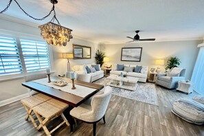 A spacious living room with a dining area, two sofas, a coffee table, and a chandelier. - PAC 201...Great Ocean View, 2nd floor 2BR/2BA condo overlooks lagoon (Saint Augustine)