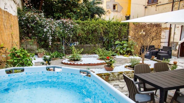 A swimming pool with a tiled deck, surrounded by potted plants and outdoor furniture. - Welcome to Il Giardino di Bryan, a peaceful oasis in the heart of La Spezia, perfect for those who want to enjoy the city while relaxing in a green and quiet environment.The house enjoys a strategic location, just 5 minutes’ walk from the train station (La Spezia)