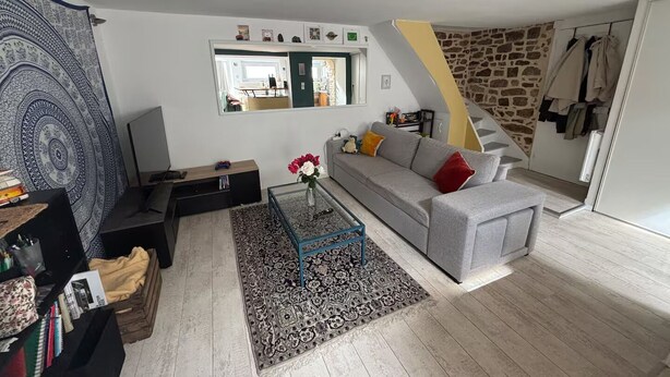 Un salon avec un canapé, une table basse et un tapis à motifs.