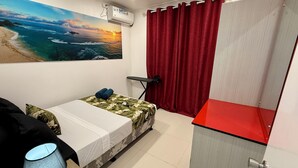 A room with a bed, a desk, a chair, a red curtain, and a wall-mounted air conditioner. - 1 Bedroom Apartment in Namadi Height, SUVA (Suva)