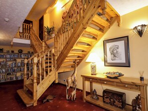 A wooden staircase with a bookshelf and a framed artwork on the wall. - Dunhallin House (Inverness)
