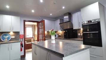 Una cocina moderna con armarios blancos, encimera de granito, horno integrado y microondas.