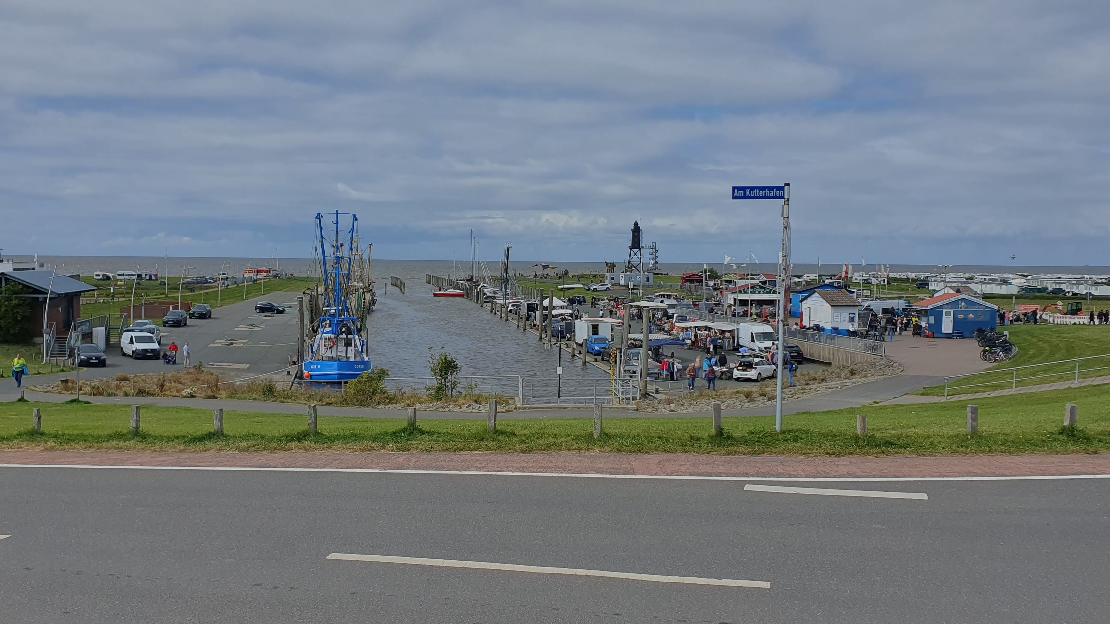 Una zona costera con un muelle, barcos y un mercado.