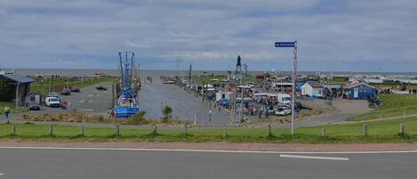 Una zona costera con un muelle, barcos y un mercado.
