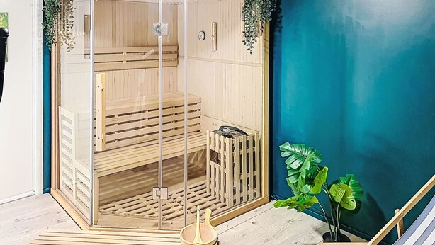 A sauna with wooden benches, a glass door, and a wooden bench outside. - Tallkotten by Interhome (Storebro)
