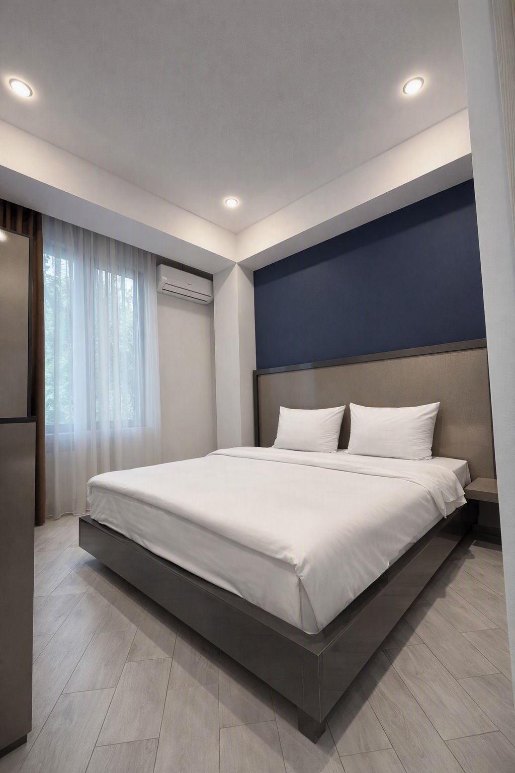Een moderne hotelkamer met een groot bed, een vastgezet hoofdbord en een klein nachtkastje.