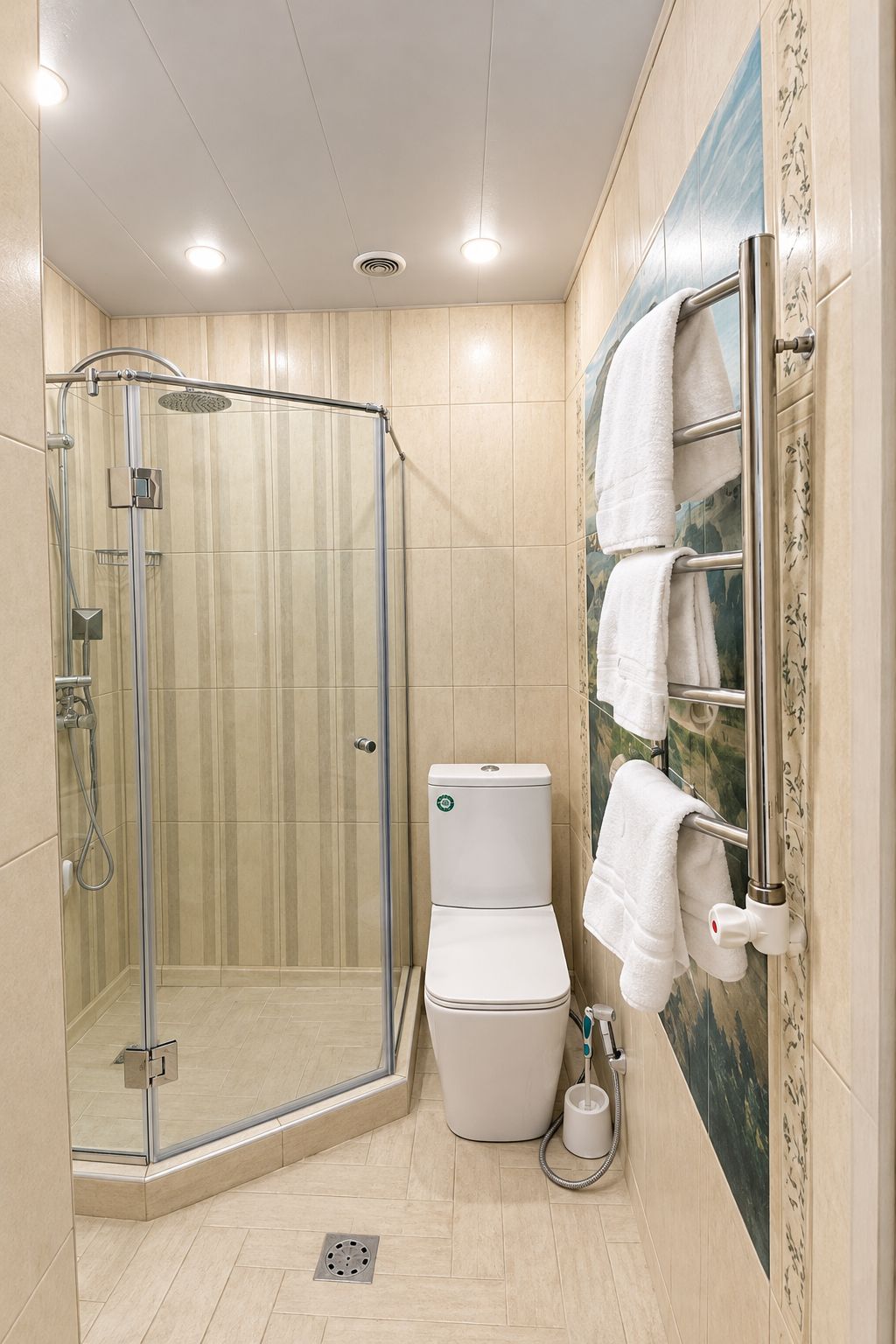 A bathroom with a glass-enclosed shower, a toilet, and a towel rack with multiple towels.