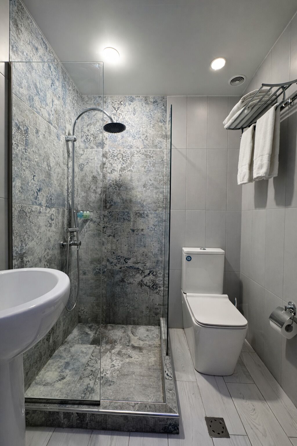 A bathroom with a shower, toilet, and sink.