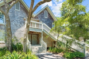 A two-story house with a porch, a staircase, and a large tree in the foreground. - Beach access, close to West Beach conference (Kiawah Island)