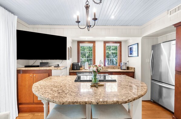 A kitchen with a granite countertop island, stainless steel appliances, and a chandelier. - Beach access, close to West Beach conference (Kiawah Island)